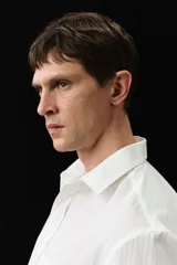 Camisa blanca de manga larga en mezcla de lyocell y algodón. Corte estándar, cuello inglés, tapeta clásica, bolsillo superior abierto, canesú con pliegue de caja en la espalda y bajo redondeado.