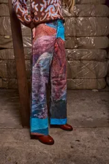 Pantalón de pana sublimado con estampado de montañas y cielo celeste. Tiro medio, corte evasé similar a un oxford, con doble botón y cierre.
