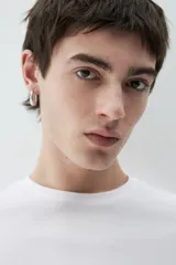 Remera blanca de corte ajustado, con cuello redondo ribeteado y bajo recto. Confeccionada con tejido funcional COOLMAX®, una fibra exclusiva de poliéster de secado rápido que elimina la humedad y regula la temperatura corporal proporcionando un ajuste cómodo y suave.