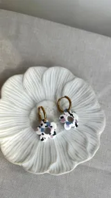 Aros colgantes con argolla dorada de acero quirúrgico y dije de flor multicolor de acrílico.