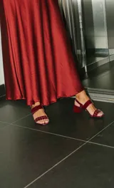 Sandalias de cuero con estampado animal print de vaca en blanco y negro, con detalles de tachas plateadas. Tienen correa trasera con hebilla y taco cuadrado de 5 cm.