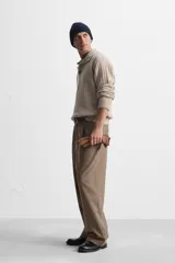 Pantalón de vestir marrón con estampado de cuadros, corte recto, tiro alto y pliegues en la cintura.