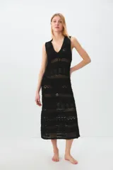 Vestido negro de tejido de punto calado, largo midi, con escote en V y tirantes anchos.