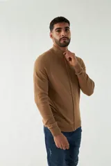 Campera tejida color marrón claro, con cuello alto, cierre frontal completo y mangas largas.