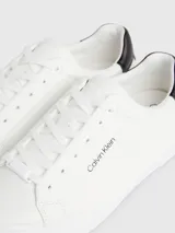 Zapatillas urbanas Calvin Klein blancas de cuero, con detalle en cuero negro en el talón y logo de la marca en el lateral.