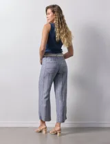 Pantalón de lino a rayas verticales azules y blancas, con corte ancho, pretina con pasadores, cierre y botones. Incluye cinto de soga con nudo.