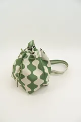 Cartera tipo tote bag con diseño tejido a rayas en verde y blanco. Tiene cordón ajustable en la parte superior y asa corta para llevar en la mano.