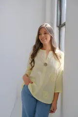 Blusa color amarillo pálido con cuello en V, manga 3/4 y calados con forma de paisley.