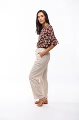 Pantalón de viscosa y lino color beige, de corte recto, con cintura elástica y cordón ajustable.