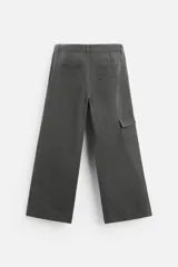 Pantalón gris oscuro de corte amplio, con bolsillos frontales y traseros de parche. Incluye un bolsillo lateral con cierre de cremallera.
