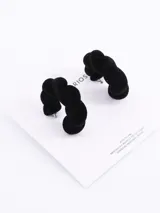 Par de aros tipo argolla gruesa, forrados en terciopelo negro y con diseño retorcido.