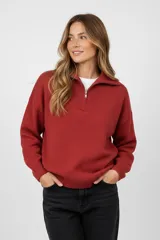 Sweater de tejido punto color terracota, con cuello polo y cierre frontal parcial, de manga larga y diseño holgado.