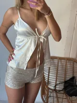 Top blanco de satén con breteles finos y lazo ajustable en el centro del busto.