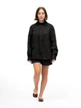 Camisa de manga larga, color negro, confeccionada en lino 100% con cuello camisero y botones frontales. Presenta un calce relajado.