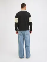 Buzo de manga larga con cuello tipo polo y fit relajado, en color negro con una franja horizontal beige en el pecho. Presenta puños acanalados y un bordado en el centro de la franja beige.