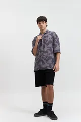 Camisa oversize de manga corta con estampado abstracto en tonos beige y blanco.