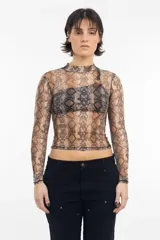 Remera de lycra traslúcida con cuello alto y estampado de piel de serpiente en tonos marrones y negros.