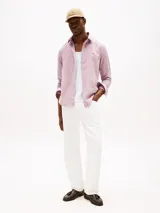 Camisa de hombre Tommy Hilfiger de manga larga, color rosa, confeccionada en algodón regenerativo de tejido dobby. Tiene cuello camisero clásico, cierre con botones, puños abotonados y logo de Tommy Hilfiger bordado en el pecho.