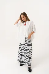 Camisa blanca con calados, escote en V, abotonada y manga 3/4.