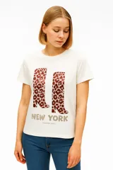 Remera color beige de manga corta y cuello redondo, con estampado de dos corazones: uno con animal print y otro con líneas.