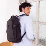 Mochila negra con bolsillo frontal vertical y capacidad para notebook. Incluye bolsillos laterales de rejilla, faja y bolsillo en la espalda para sujetarla a la valija, además de correas con broches laterales para ajuste.