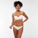 Conjunto de lencería blanco, compuesto por un sostén con aro y breteles regulables, y una bombacha tipo bikini.