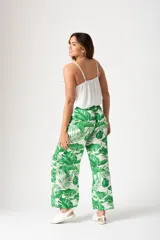 Pantalón palazo verde con estampado de hojas de palmera blancas, cintura elastizada con lazo y corte amplio.