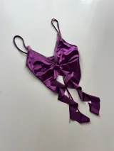 Conjunto de lencería negro con detalles de encaje, compuesto por un top con escote en V y una minifalda con volados.