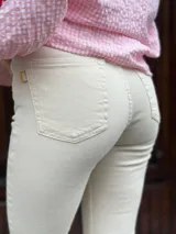 Pantalón de jean color crudo, de corte semioxford con aberturas en el ruedo.