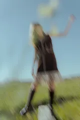 Vestido corto marrón de gamuza sintética, sin mangas, con escote en V y detalle de flecos en el ruedo. Presenta apliques bordados en el frente y laterales.