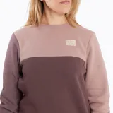Buzo de mujer con diseño color block en tonos celeste, gris oscuro y rosa. Tiene cuello redondo, mangas largas y logo bordado en el pecho.