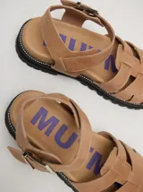 Sandalias romanas color verde oliva, con tiras entrecruzadas y hebilla lateral. Suela de goma negra con plataforma de 3cm. Fabricadas en cuero vacuno.