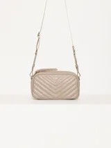 Bandolera color beige con diseño acolchado en forma de V y logo metálico dorado en forma de labios. Tiene correa larga ajustable y herrajes plateados.