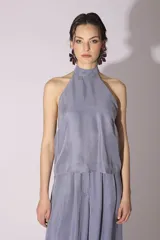 Conjunto de blusa y pantalón color gris azulado de seda, con cuello halter y corte holgado.