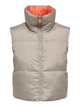 Chaleco acolchado color beige con cuello alto y cierre frontal con cremallera. El interior es color naranja.