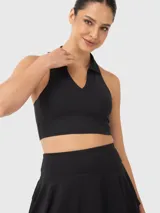 Top deportivo negro con cuello polo y espalda descubierta.