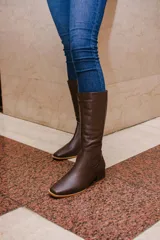 Bota de caña alta de cuero color rojo, con cierre lateral y taco cuadrado de 4 cm.