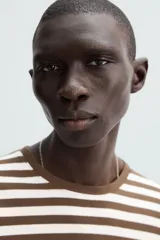 Remera de manga larga a rayas horizontales marrones y blancas, de corte recto y cuello redondo.