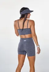 Conjunto deportivo gris jaspeado compuesto por top con breteles finos y logo 'bk.' estampado en el frente, y short de calce ajustado.