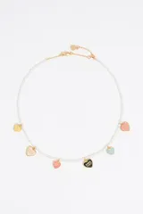 Collar corto de perlas con dijes de corazón multicolor con detalles dorados.