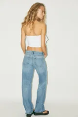 Top bandeau color crema con escote recto, hombros descubiertos y detalle de volantes en capas.