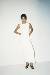 Vestido midi blanco de tejido de punto, con cuello redondo, sin mangas, drapeado en el frente, forro interior y abertura en la espalda.