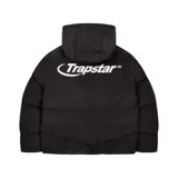 Campera puffer negra con capucha y logo Trapstar en la espalda.