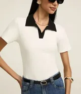 Blusa blanca acanalada de rib con cuello polo negro contrastante y mangas cortas.