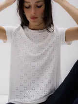 Camiseta blanca de algodón con pequeños calados en forma de flor.