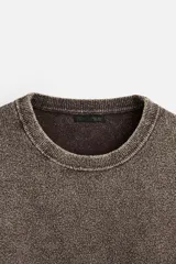 Sweater marrón de cuello redondo y manga larga, tejido con textura bouclé y efecto lavado.