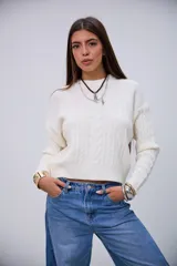 Sweater de punto color crudo con cuello redondo, diseño de ochos y mangas largas.