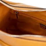 Cartera tipo hobo color habano, confeccionada en cuero sintético graneado. Tiene un compartimento principal con cierre, un bolsillo interno con cierre y otro abierto. Incluye correa regulable y asa fija.