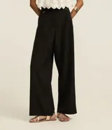 Pantalón negro de vestir, corte wide leg, cintura alta con doble pretina y detalle de remaches.