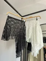 Minifalda negra de encaje con volados y cintura elastizada.